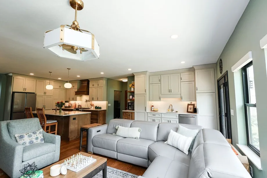 Open living room with built-ins and stone fireplace by Padgett