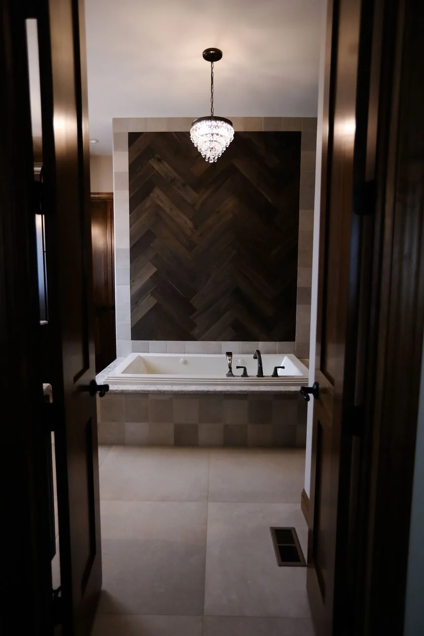 Remodeled bathroom with freestanding tub and wood accent wall by Padgett